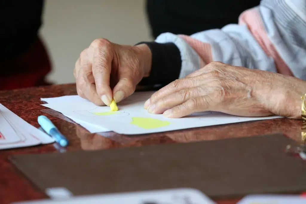 Personne âgée entrain de colorier sur une feuille