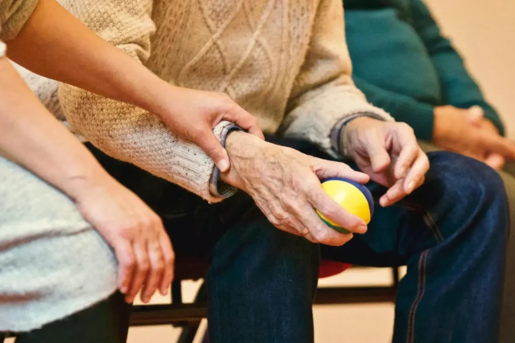 Une personne assise avec une balle jaune dans la main
