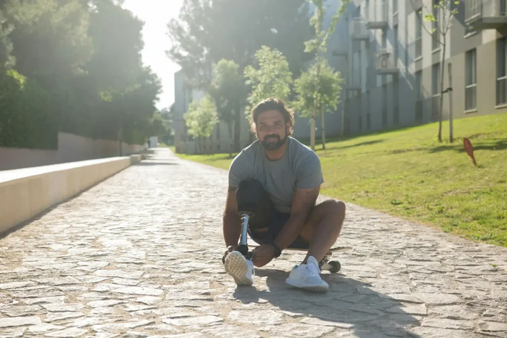 Personne paraplégique assise au sol sur une allée.