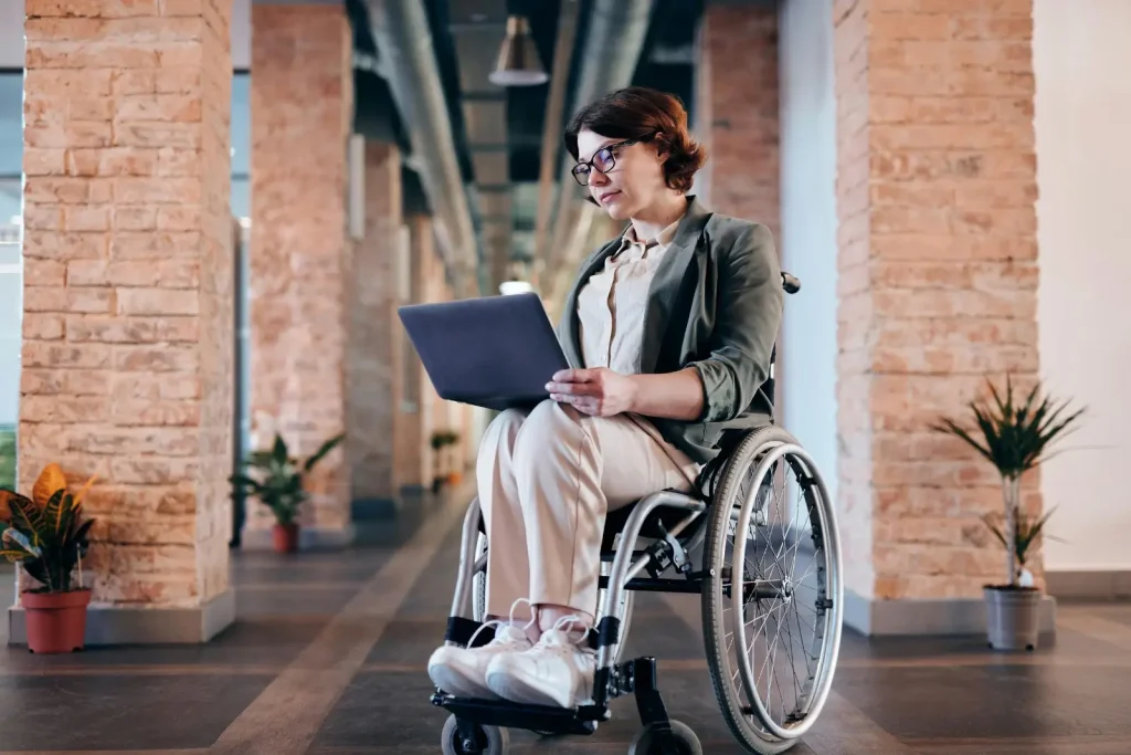 femme sur un fauteuil roulant avec une tablette dans les mains