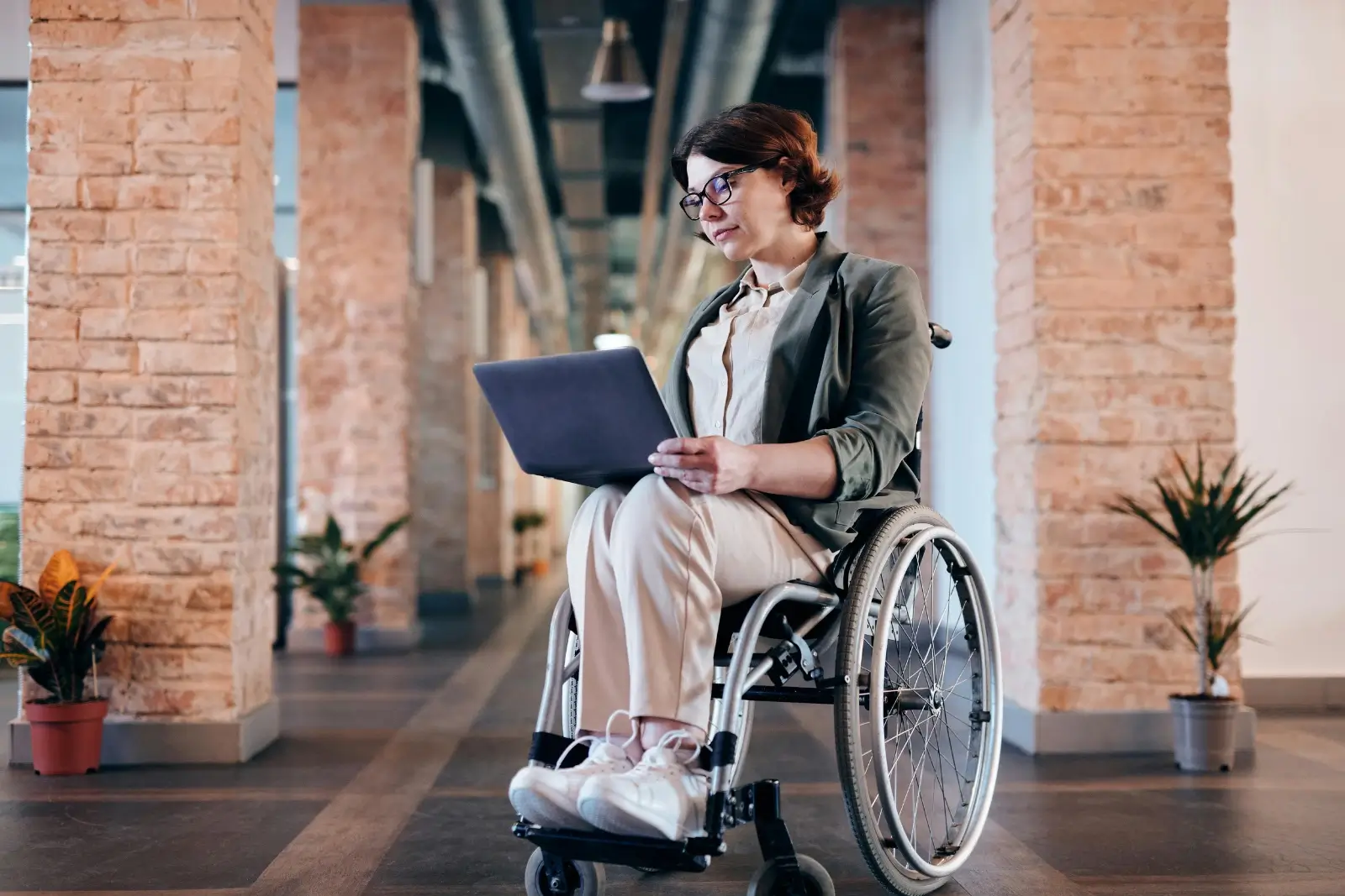 femme sur un fauteuil roulant avec une tablette dans les mains