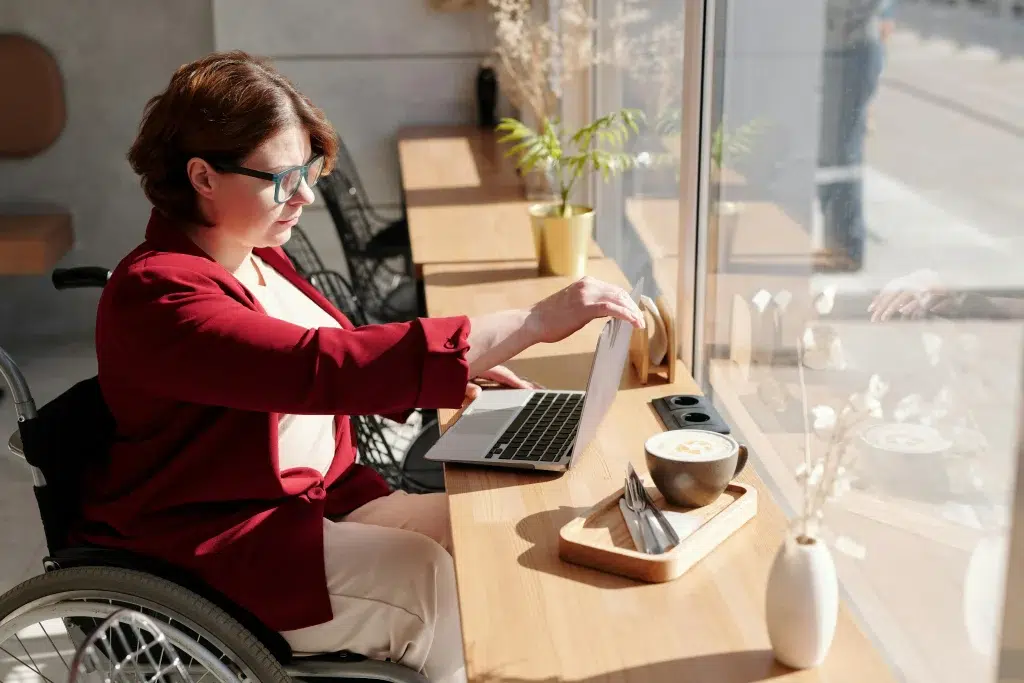Personne assise avec son ordinateur sur un bureau
