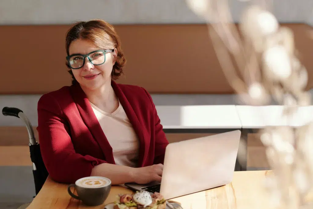 Femme assise sur un bureau avec son ordinateur
