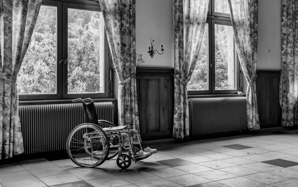 Fauteuil roulant au milieu d'une pièce avec fenêtres.
