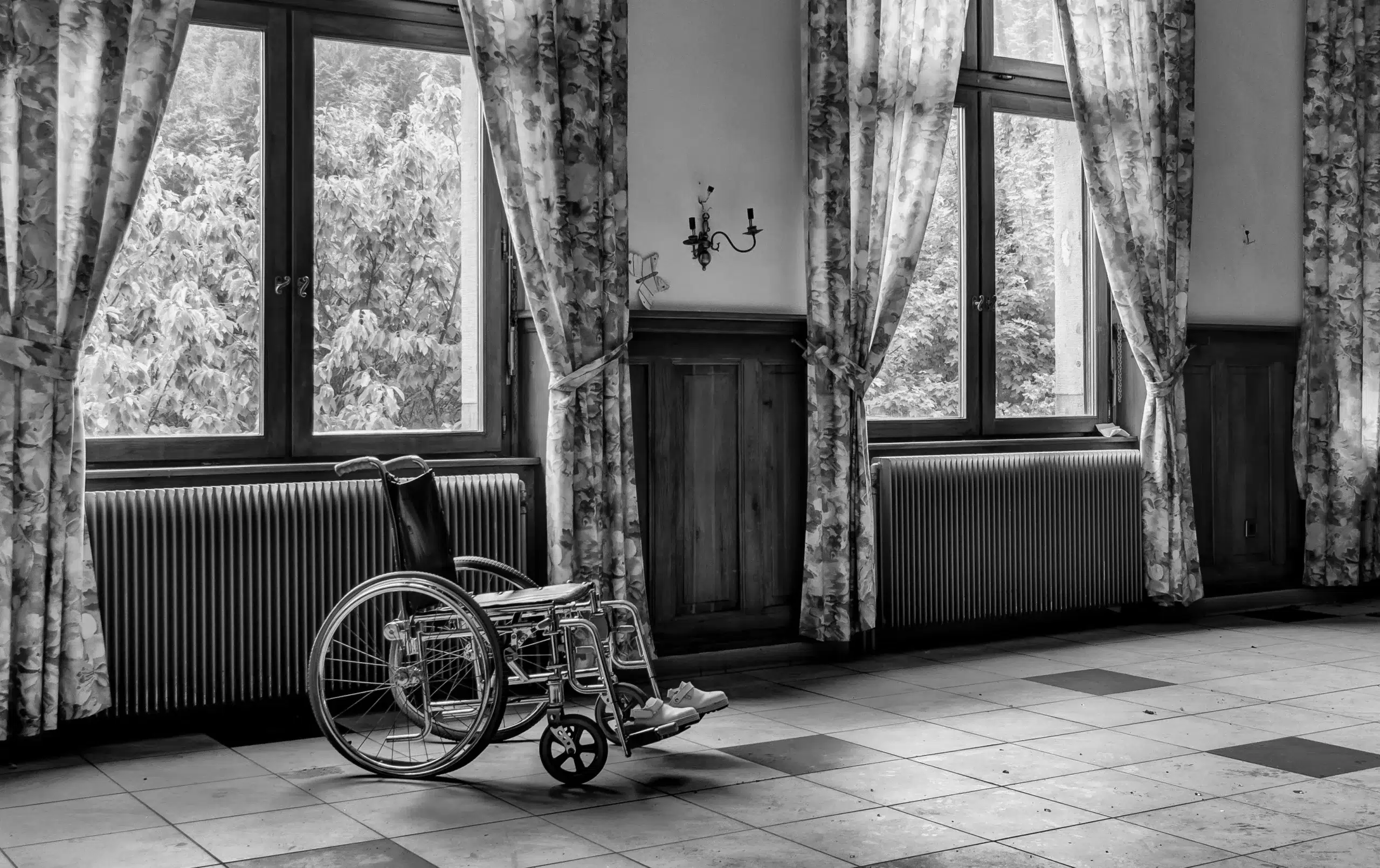 Fauteuil roulant au milieu d'une pièce avec fenêtres.